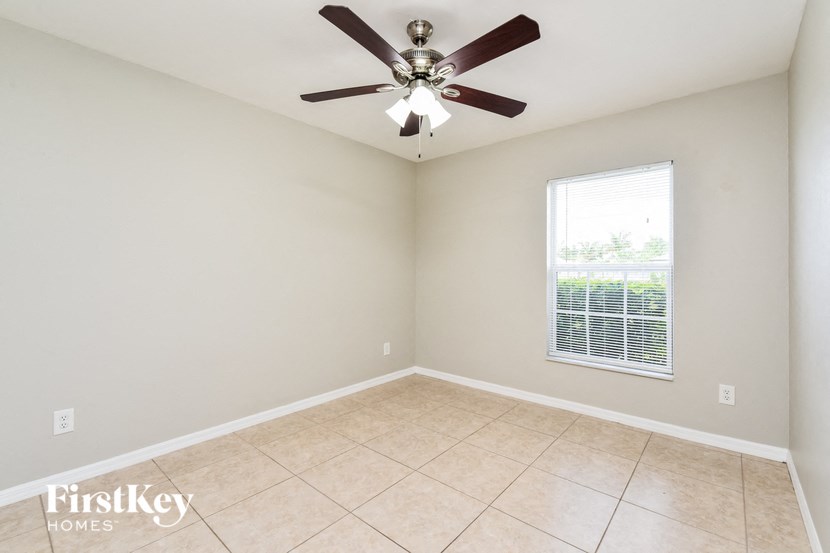 an empty room with a ceiling fan and a window