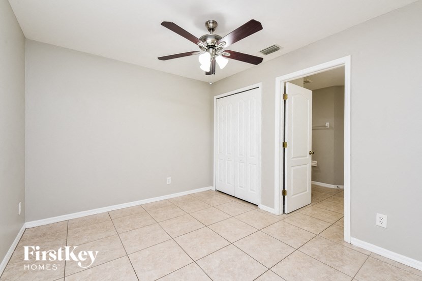 the living room has a ceiling fan and tile flooring