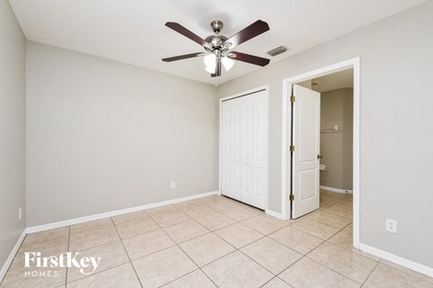 the living room has a ceiling fan and tile flooring