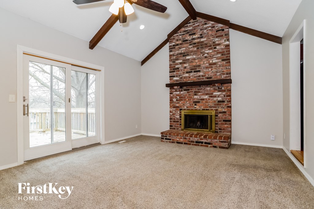 an empty living room with a fireplace and a sliding glass door