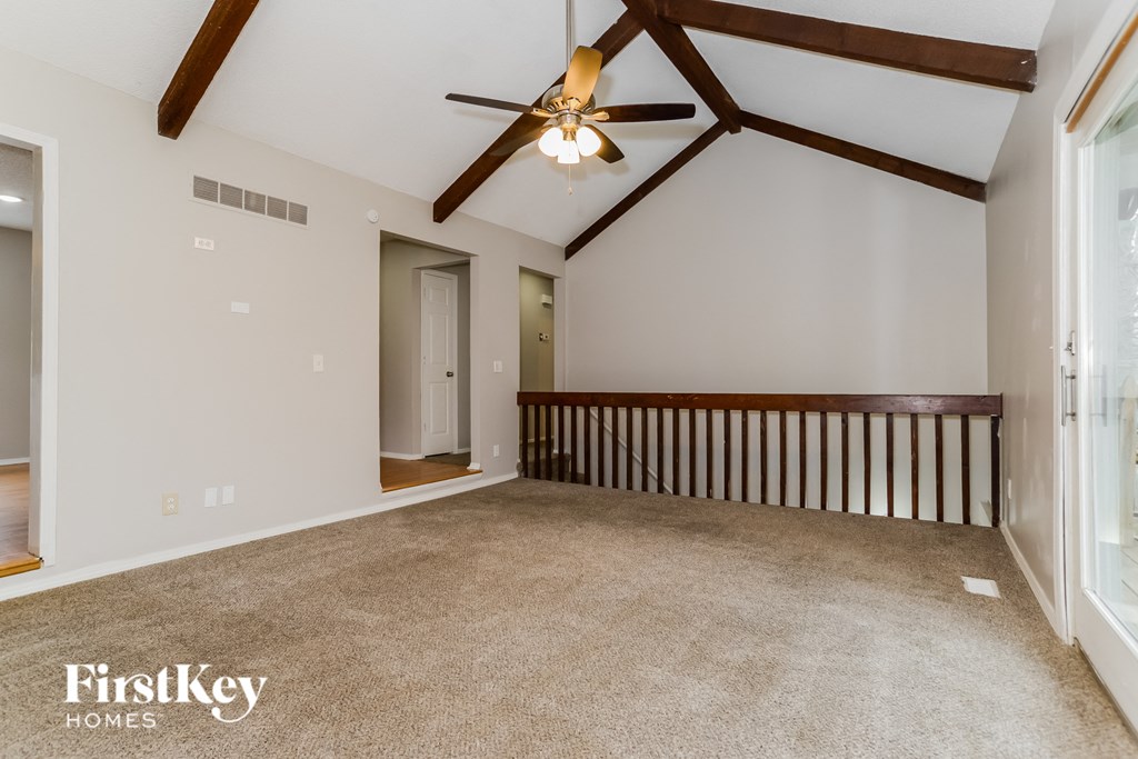 the master bedroom is open to the loft and has a ceiling fan