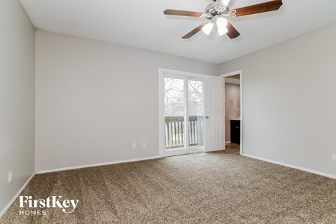 a living room with carpet and a ceiling fan