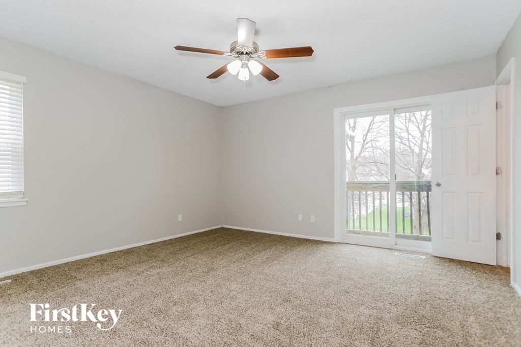 a bedroom with a ceiling fan and a window