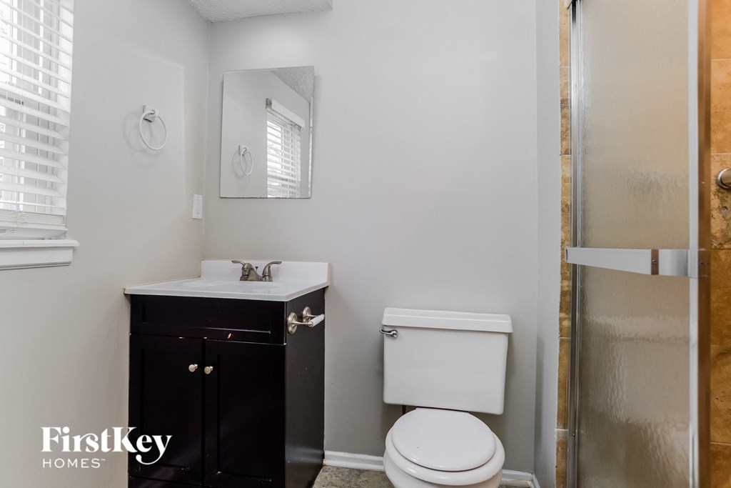 a bathroom with a toilet and a sink and a shower