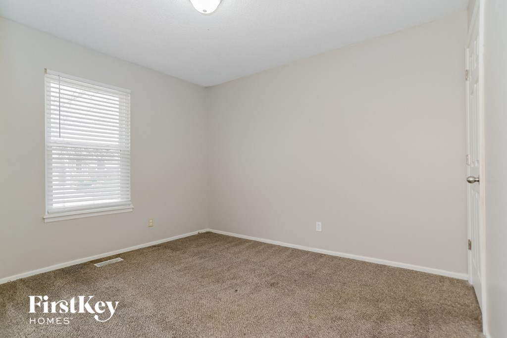 a bedroom with a carpeted floor and a window