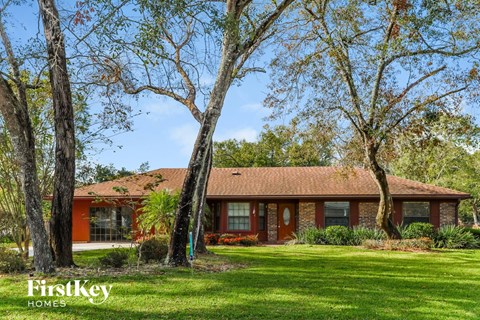 a red brick house with trees in front of it