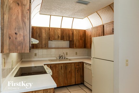 a kitchen with wooden cabinets and a sink and a refrigerator