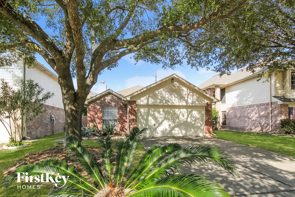 a house with a garage and a palm tree in front of it