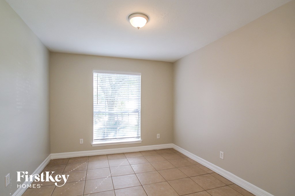 a dining room with a large window and a tiled floor