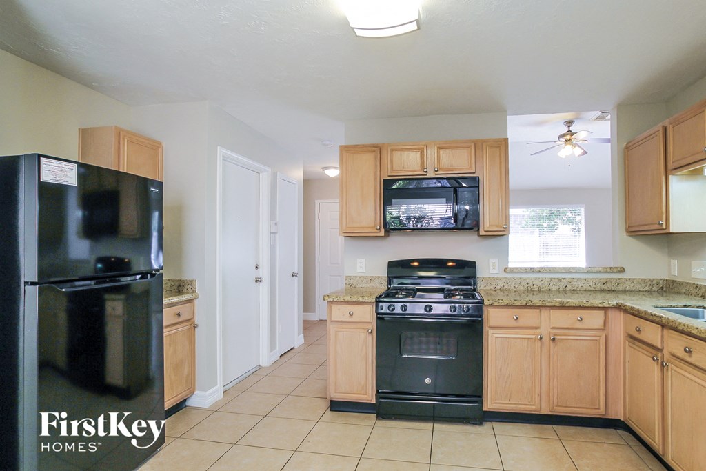 a kitchen with wooden cabinets and black appliances