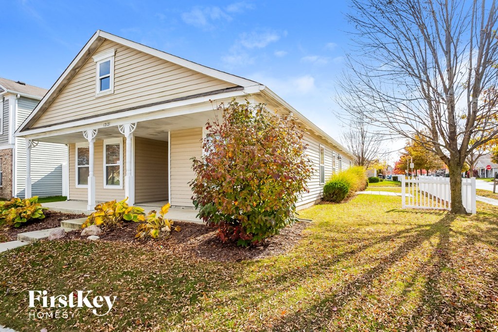 A house with a white picket fence in front of it.
