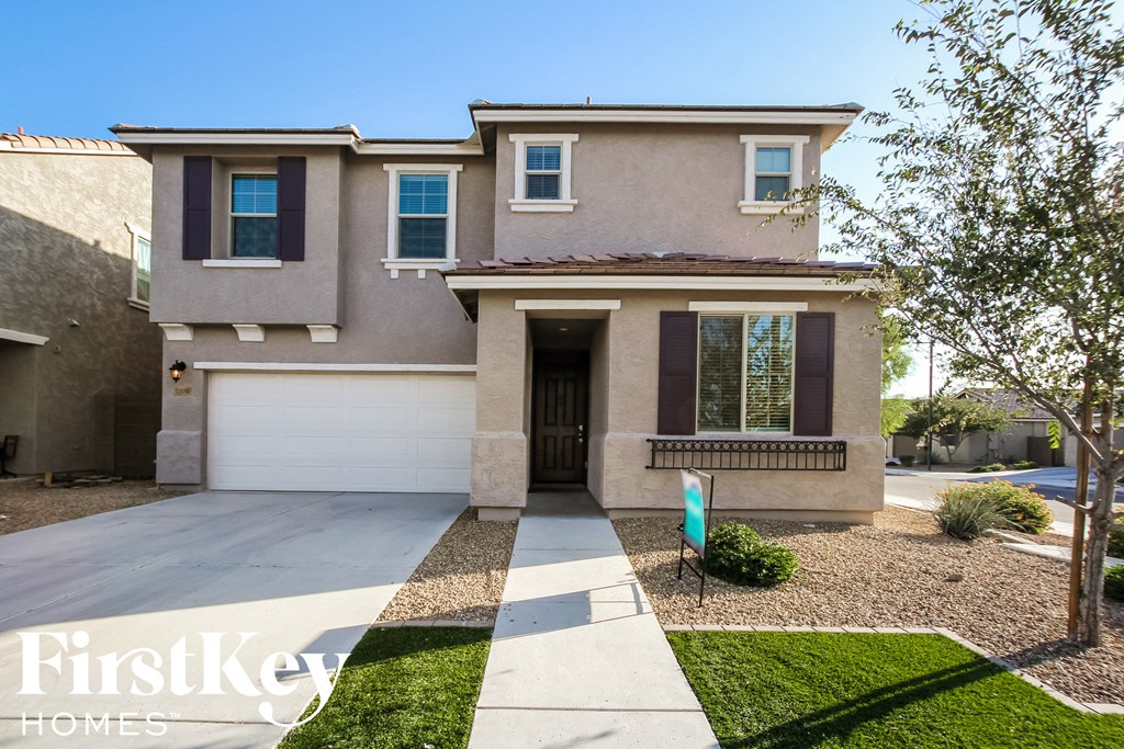 a house with a garage door and a sidewalk in front of it