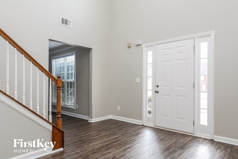 a living room with a staircase and a white door
