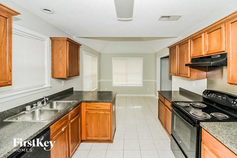 A kitchen with wooden cabinets and black appliances.