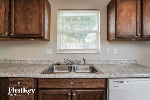 A kitchen with wooden cabinets and a double sink.