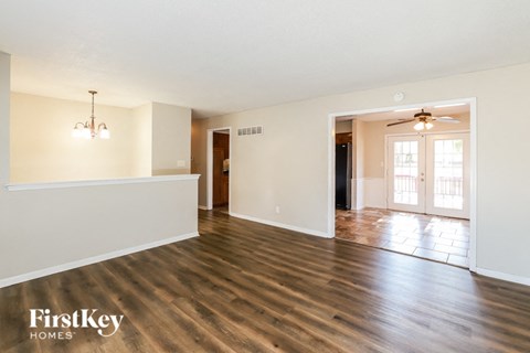 an empty living room and dining room with wood flooring