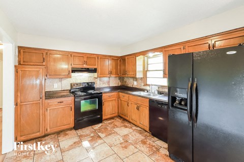 a kitchen with black appliances and wooden cabinets