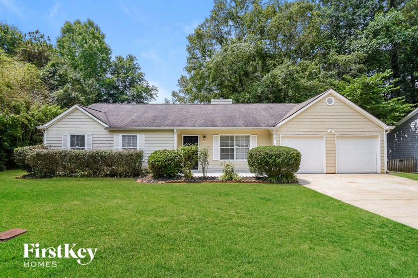 a white house with a lawn and a driveway