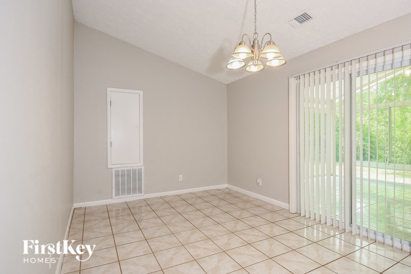 an empty living room with a sliding glass door to the yard