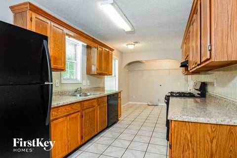 a kitchen with wooden cabinets and a black refrigerator