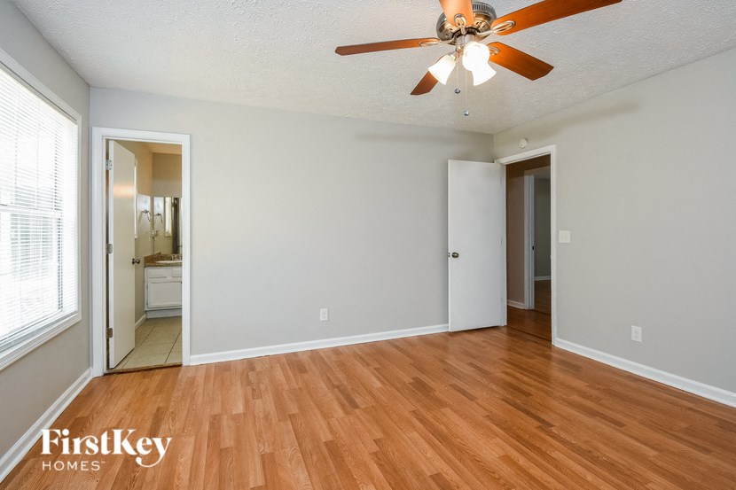 an empty living room with wood flooring and a ceiling fan