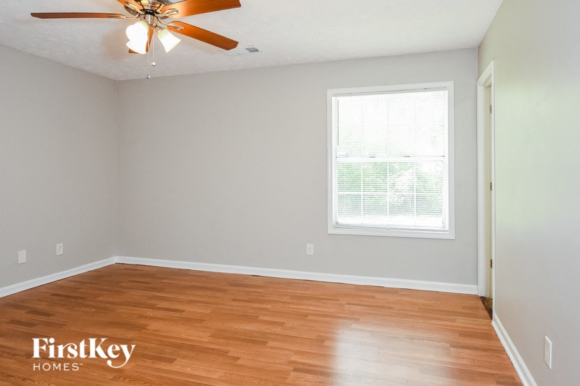 a living room with wood floors and a ceiling fan