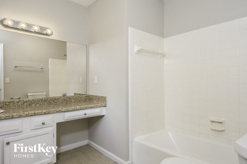 a bathroom with a sink and a tub and a mirror