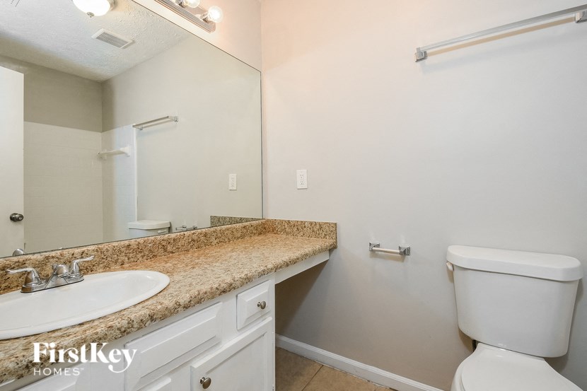 a bathroom with a toilet and a sink and a mirror