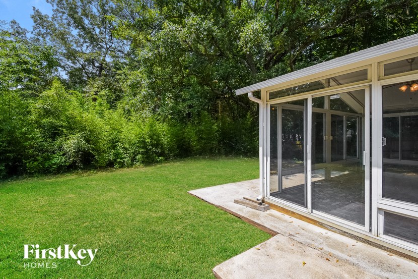 a patio in the backyard of a home with glass doors