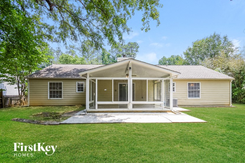 a yellow house with a porch and a grassy yard