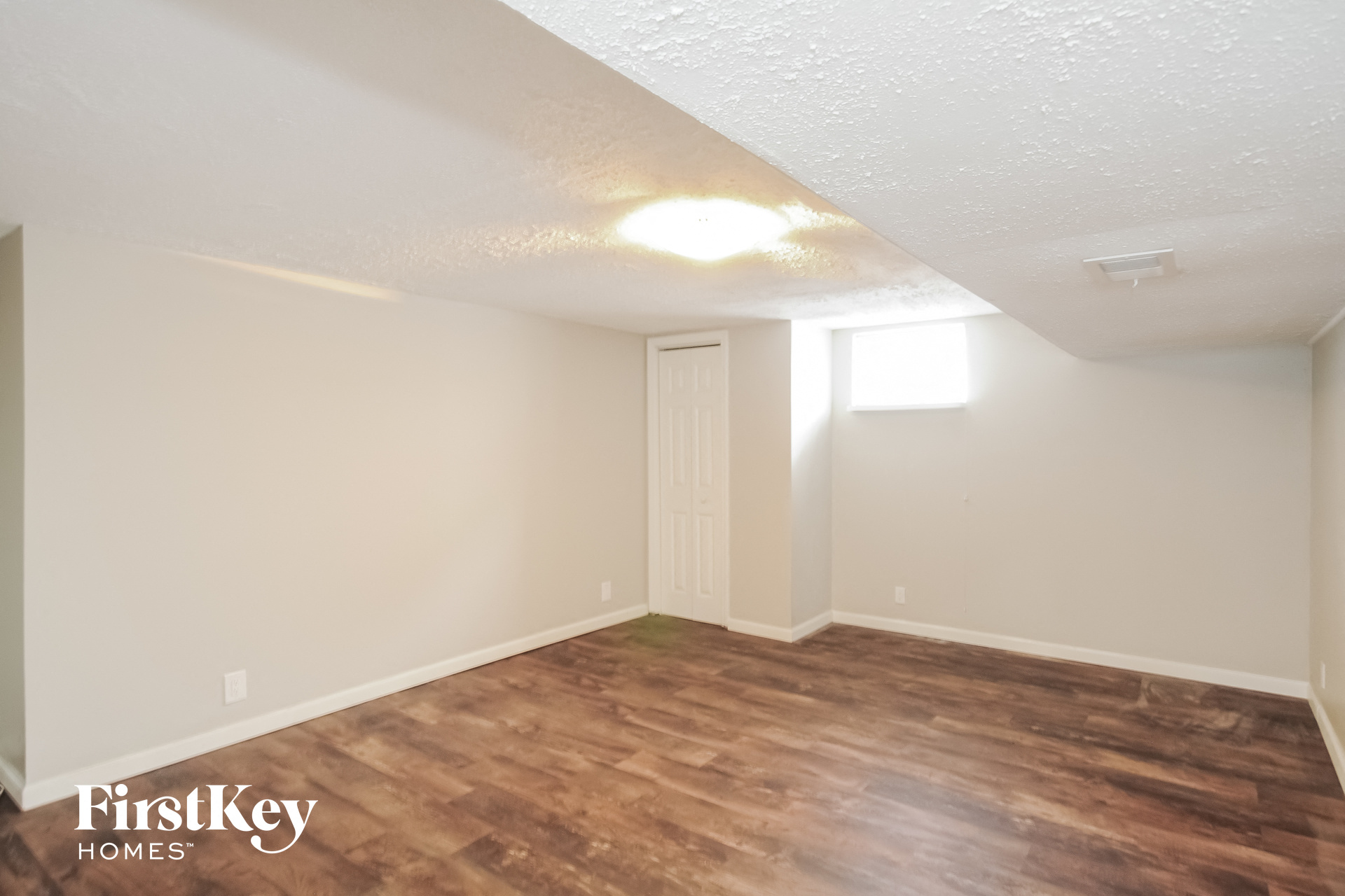 a living room with a wooden floor and white walls