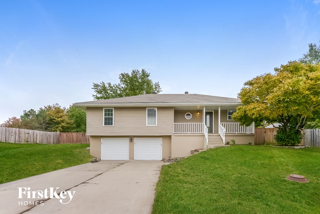 the front of a house with a yard and a sidewalk