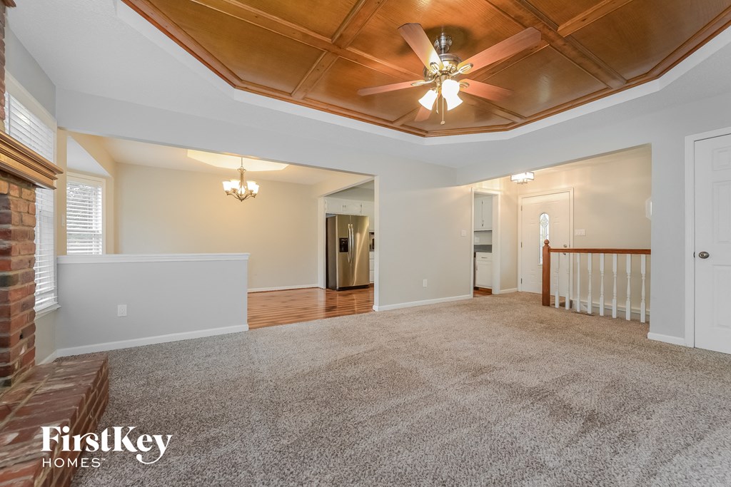 an empty living room with a ceiling fan