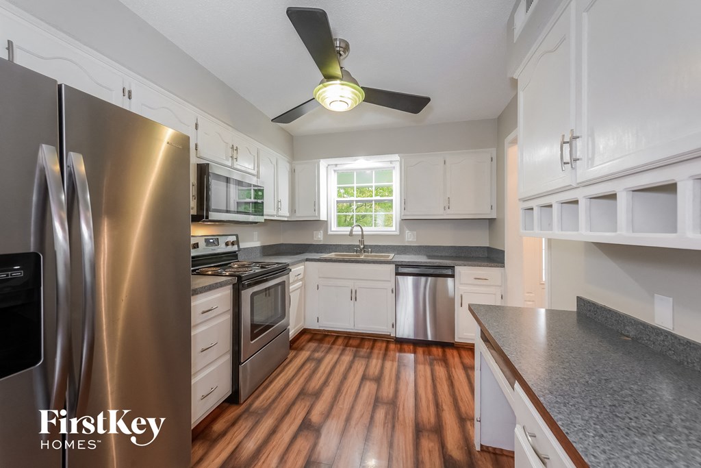 a kitchen with stainless steel appliances and white cabinets