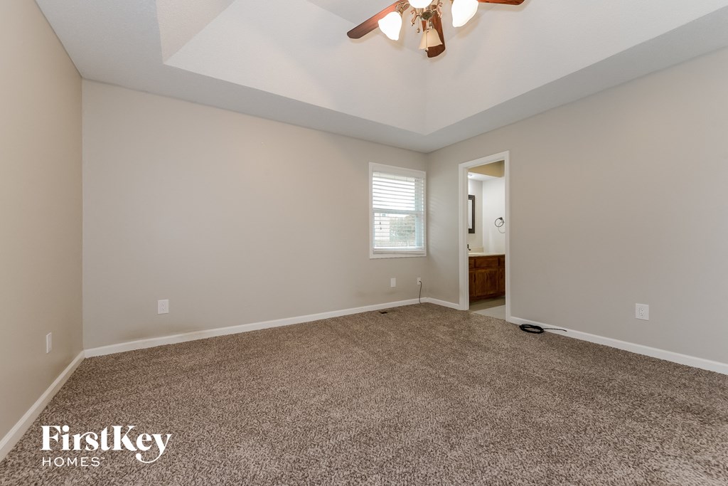 the living room is spacious and clean with a ceiling fan