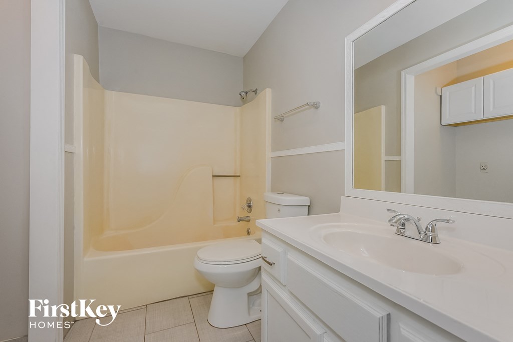 a bathroom with a toilet and a sink and a mirror
