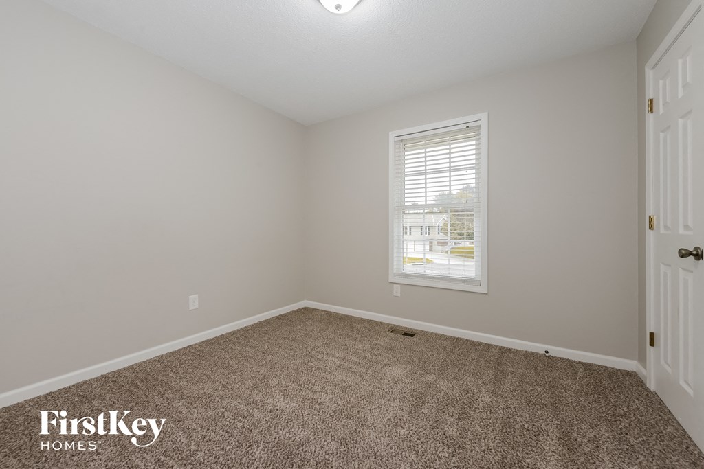 a bedroom with a carpeted floor and a window