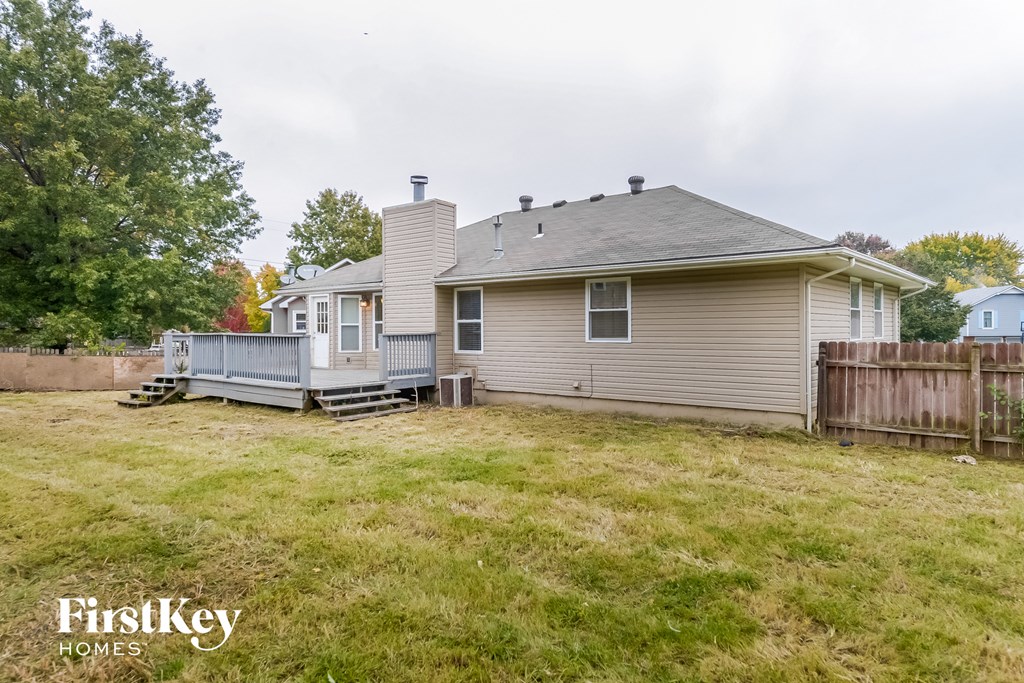 the back of a house with a yard and a deck