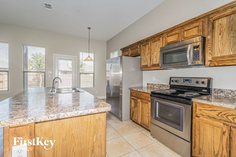 A kitchen with wooden cabinets and granite countertops.