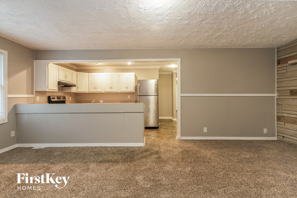 the kitchen and living room of an empty house