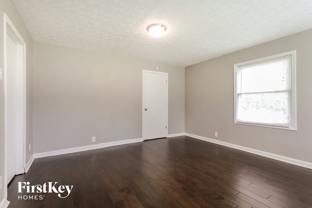 the living room with hardwood flooring and a window