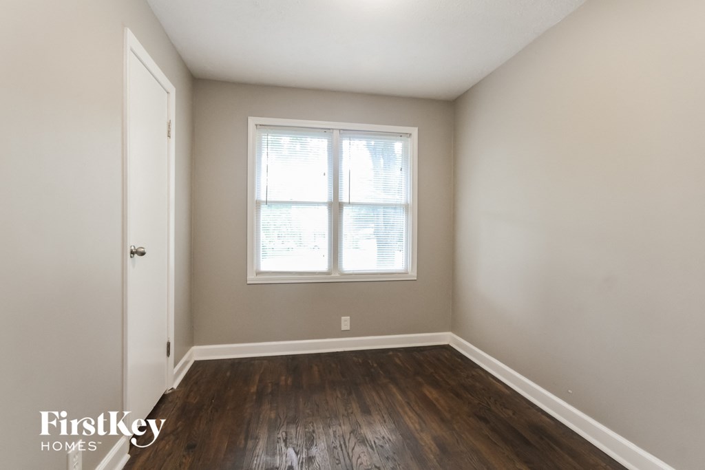 an empty room with hardwood floors and a window