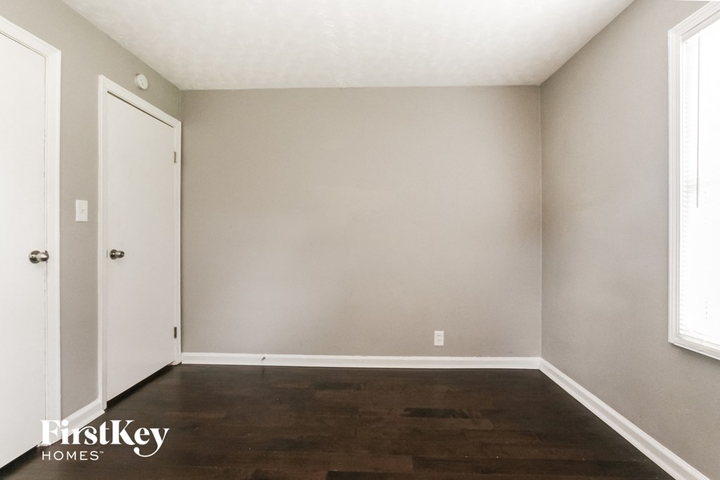 a empty room with wood floors and a white door