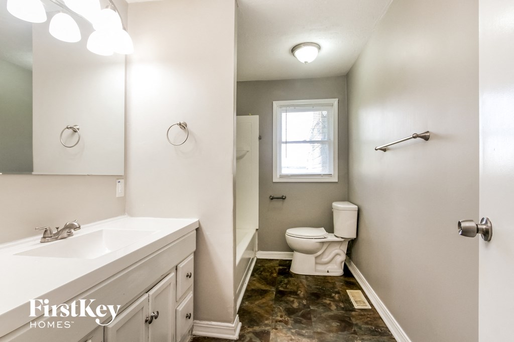 a bathroom with a toilet and a sink and a mirror