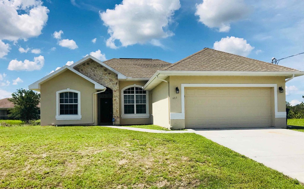 A two-story house with a garage on the right side.