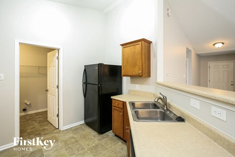 a kitchen with a black refrigerator and a sink