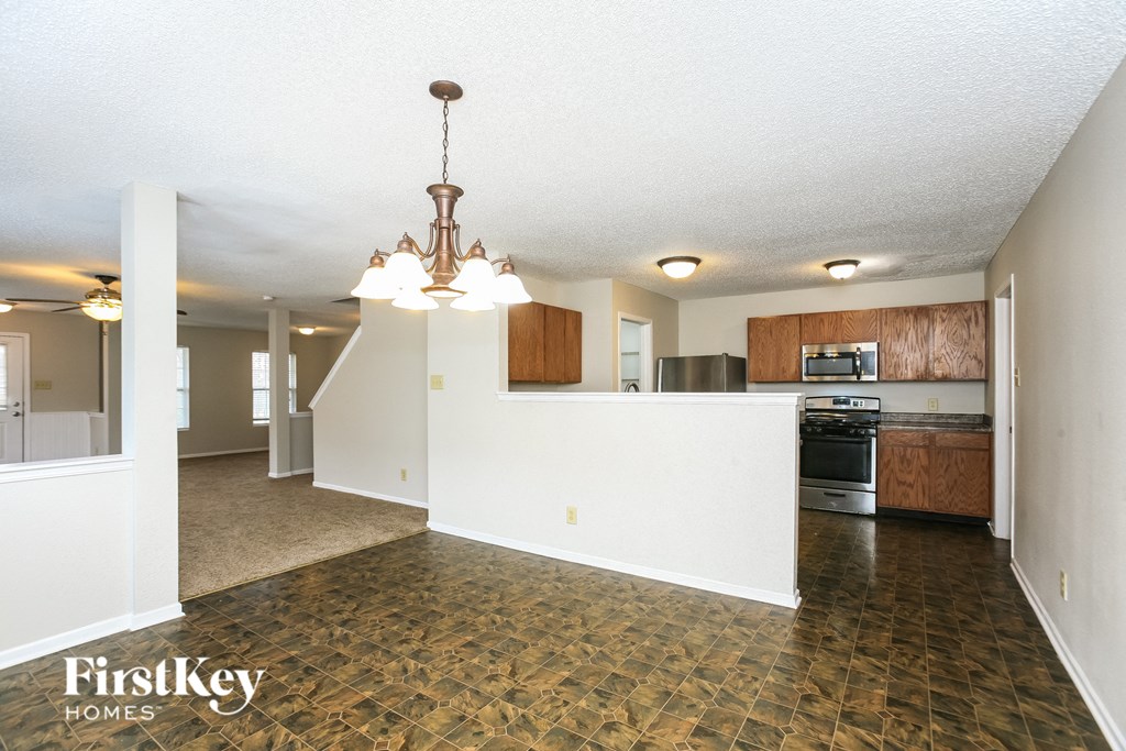 A kitchen area with a tile floor and a chandelier hanging from the ceiling.