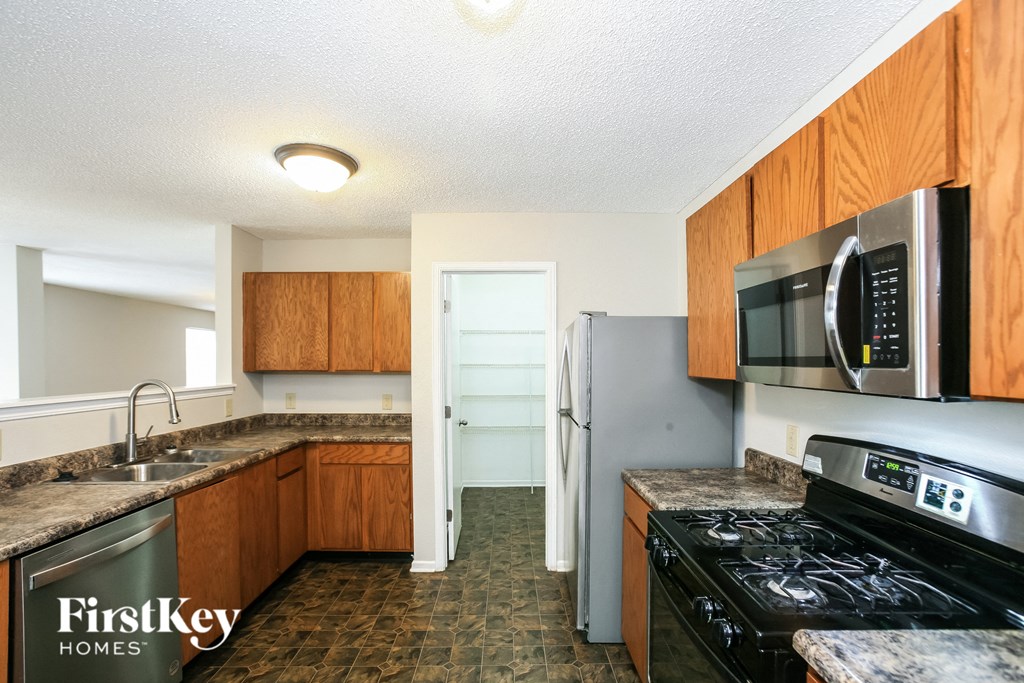 A kitchen with a stove top oven and a microwave above it.