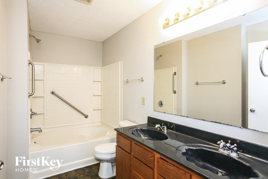 A bathroom with a white tub, sink, and toilet.