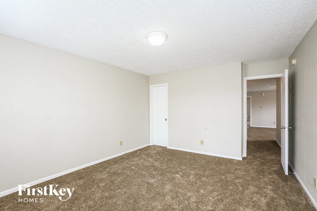 A room with a carpeted floor and a doorway leading to another room.